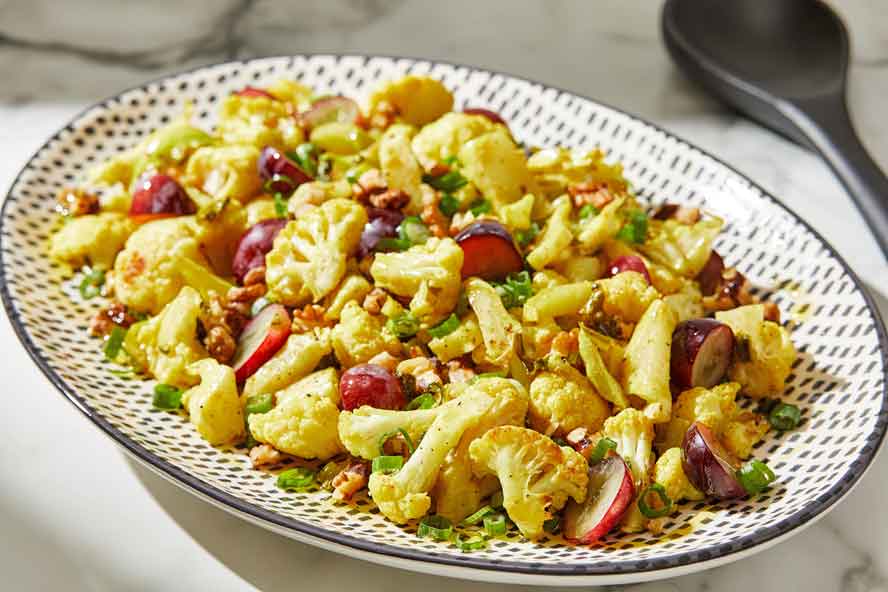 Curried cauliflower salad has crunchy walnuts and pops of sweetness from grapes

