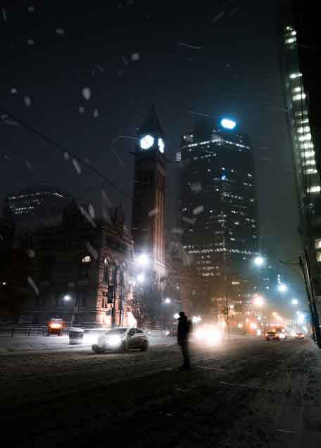 A man walking through a big city snowstorm
	